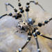 Beaded wire spider ornament featuring black seed beads, silver metal accents, and crystal-style details.